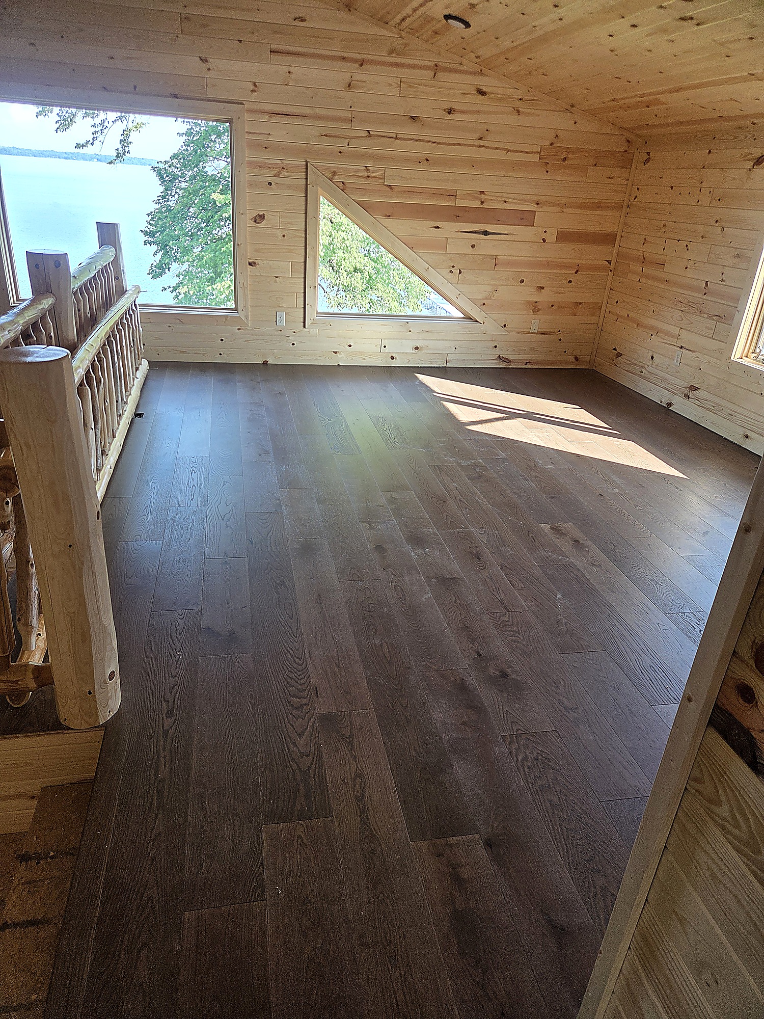 Engineered hardwood flooring beside a stone fireplace