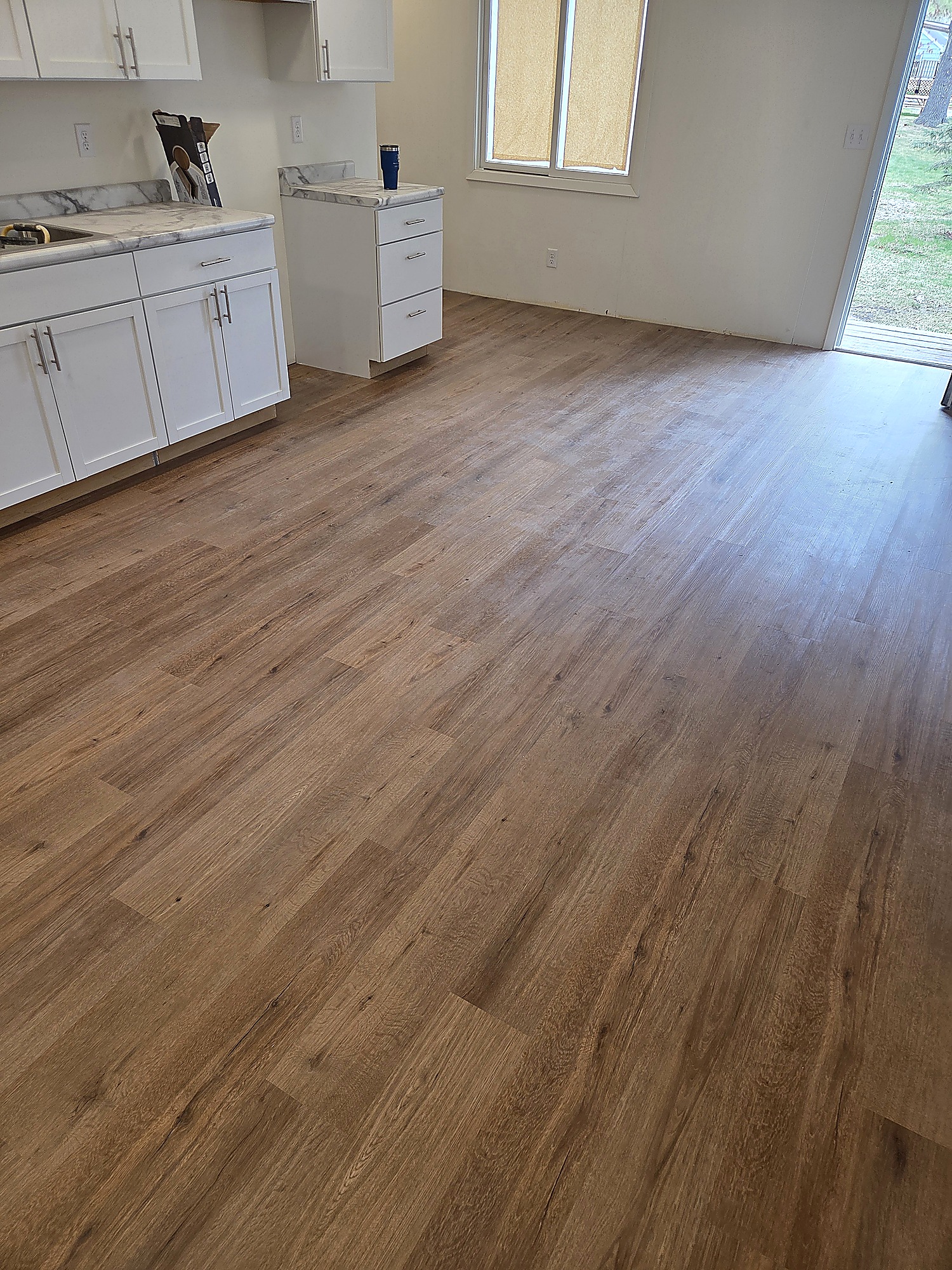 Wood-look plank flooring in a kitchen with white cabinets