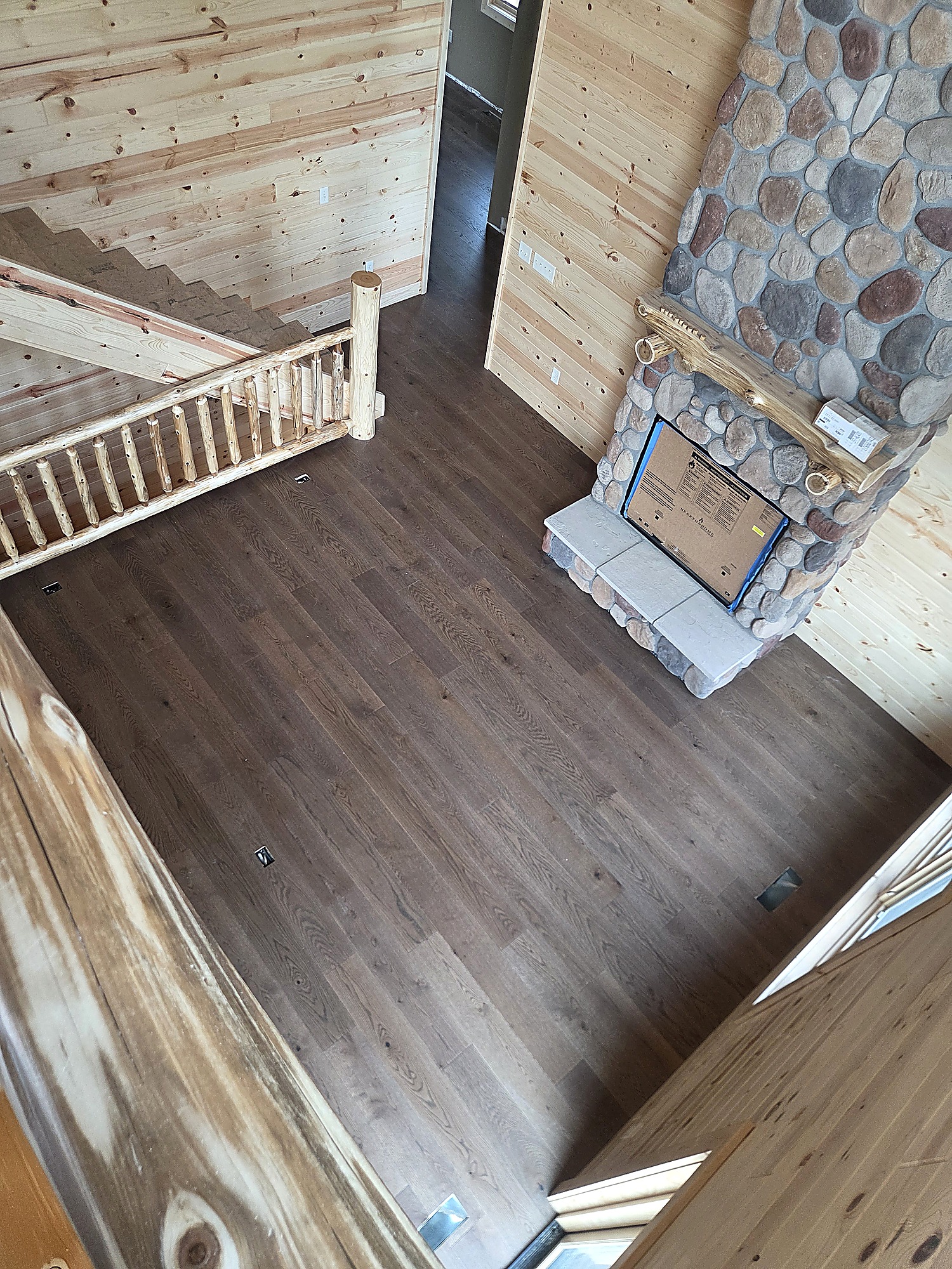 Overhead view of engineered hardwood flooring with a log railing