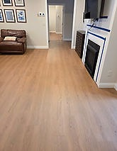 Luxury vinyl plank flooring in a living room with fireplace