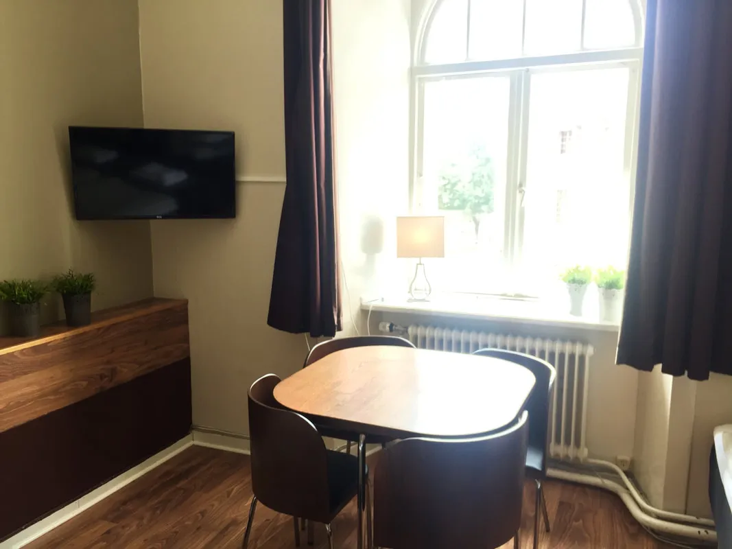 Fyrbäddsrum på Järnvägshotellet med matbord och fönster
