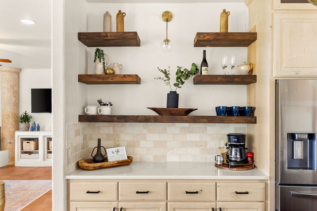 Dedicated coffee bar with floating rustic wood shelves, glassware, mugs, and coffee maker at The Point CLTX