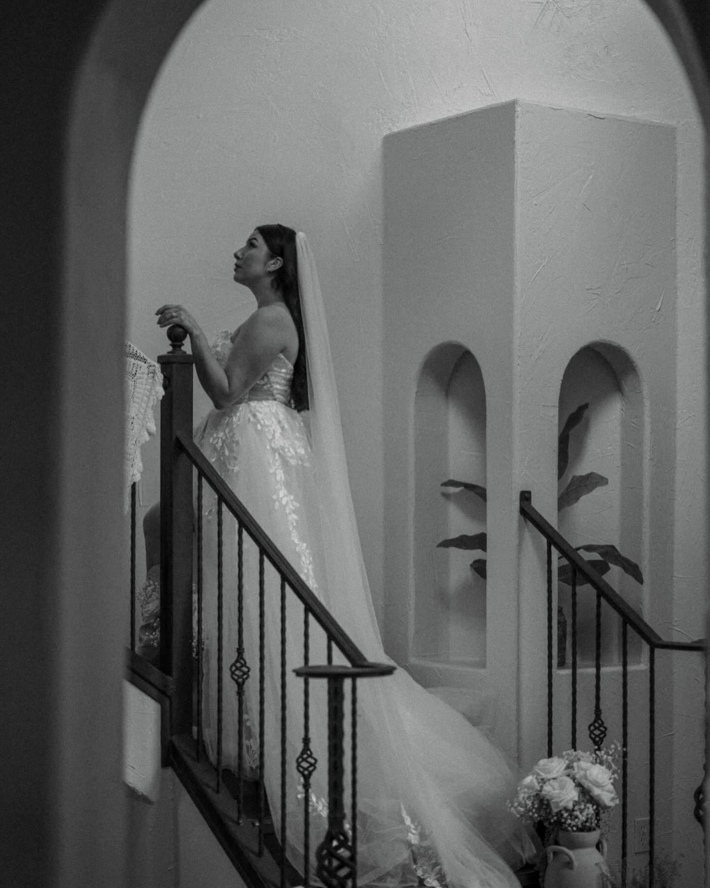 Bride in flowing gown and veil on the architectural staircase inside The Point CLTX