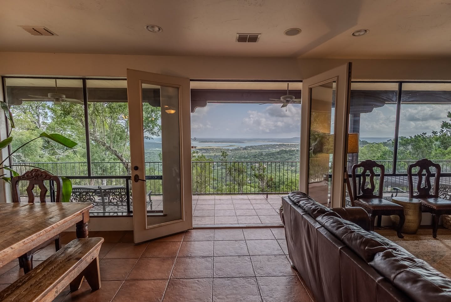 Hill Country lodge living area opening to panoramic Canyon Lake views from the balcony at The Point CLTX