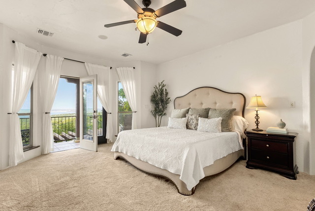 Elegantly appointed bridal suite bedroom with king bed and French doors opening to private Canyon Lake balcony