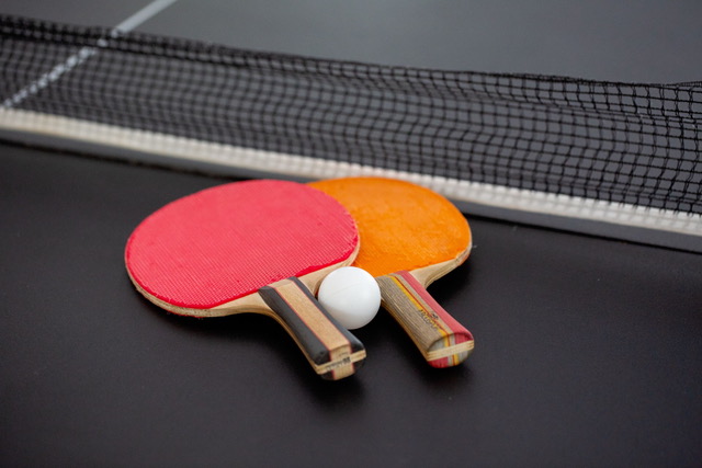 Table tennis paddles and ball ready for games and group recreation at The Point CLTX