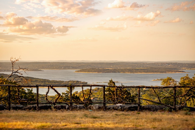 The Point CLTX overlooking Canyon Lake with rustic cedar railing reading LOVE at golden hour in the Texas Hill Country