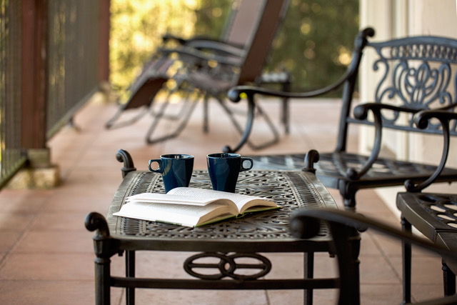 Relaxing patio with coffee mugs, open book, and lounge seating on the Hill Country balcony