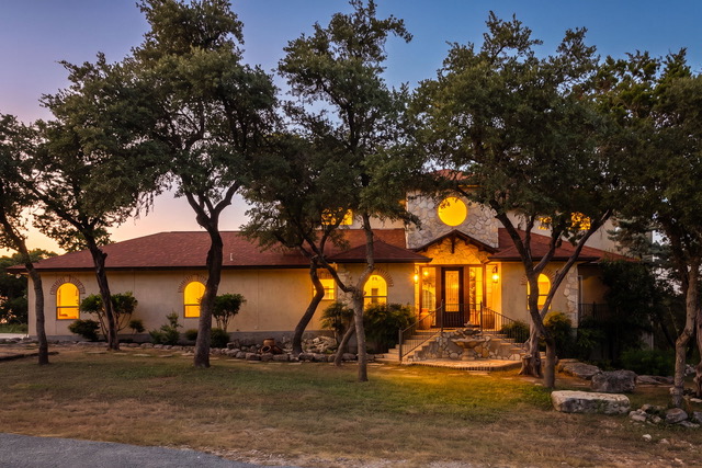 The Point CLTX Spanish-style lodge illuminated at twilight among oak trees for group retreats