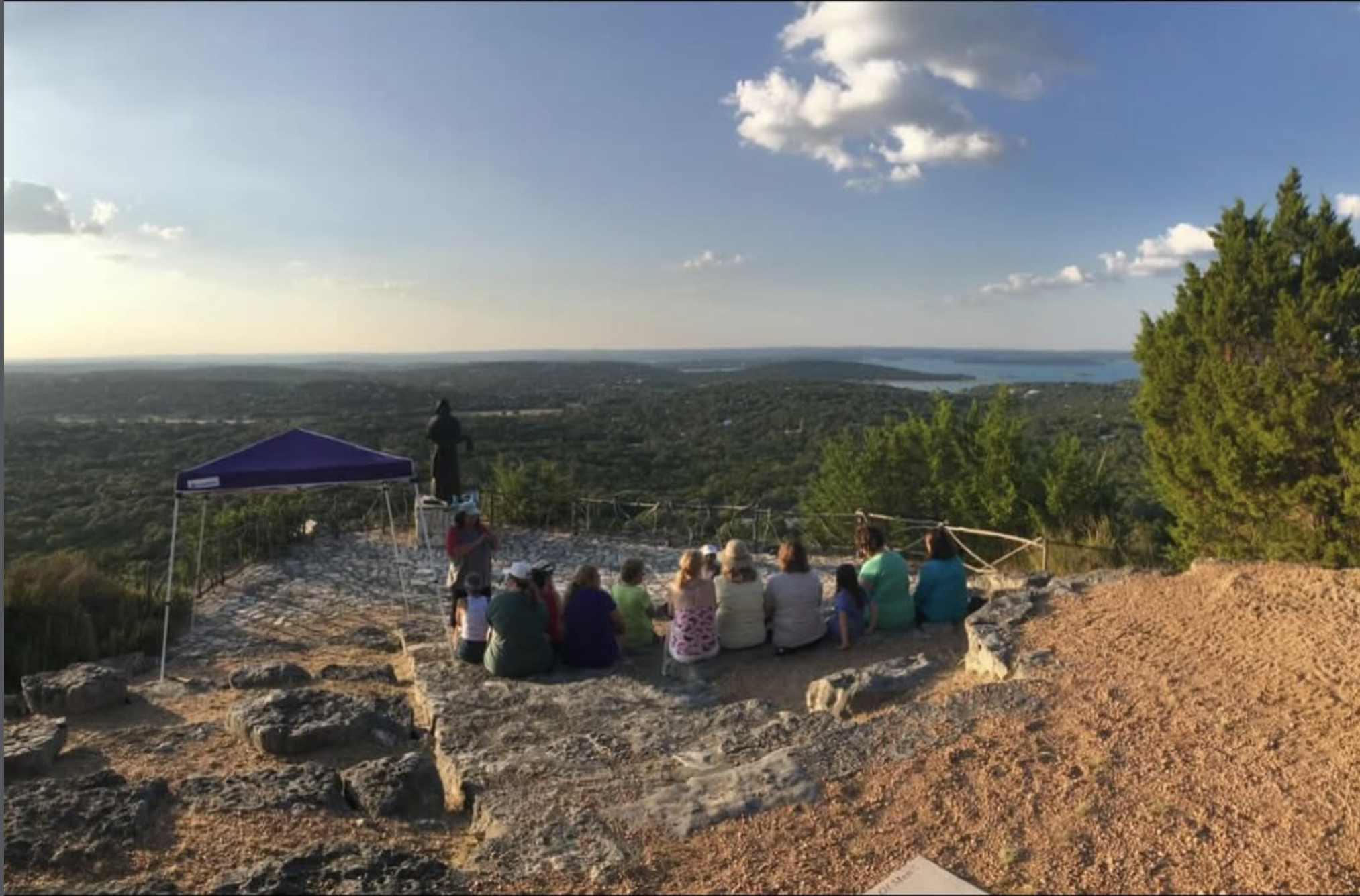 Family and friends gathered together on the stone overlook with expansive views across Canyon Lake and the Hill Country