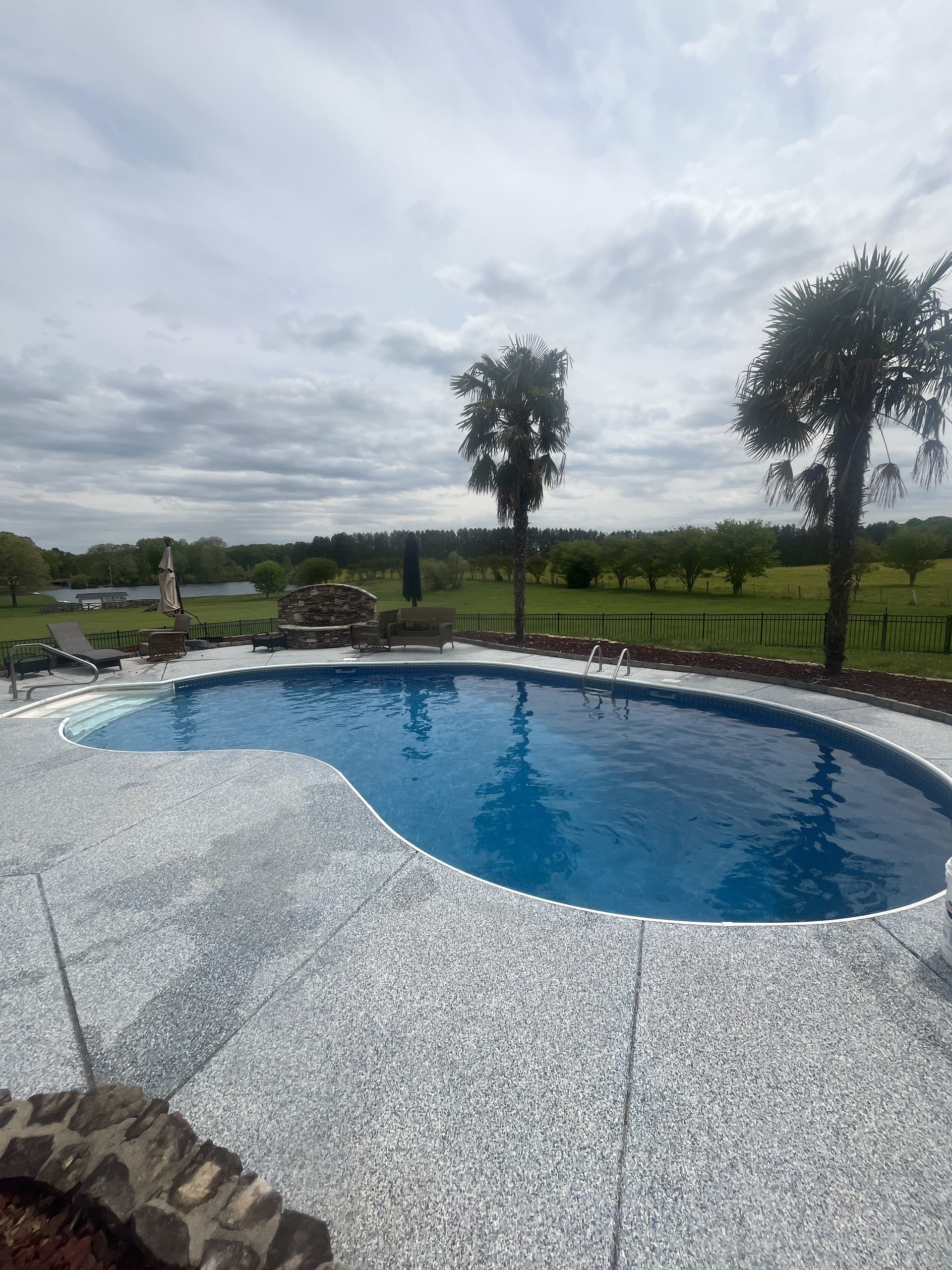 Spotless residential swimming pool with clear water and attractive surrounding patio and landscape