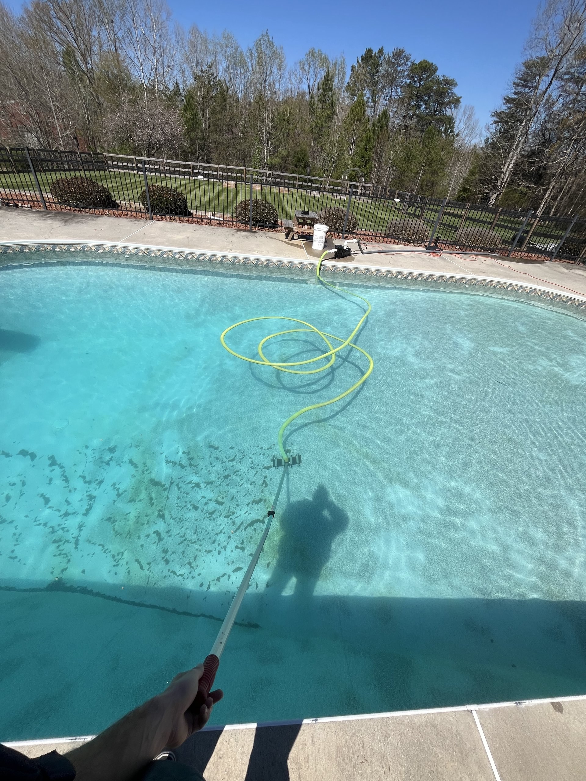 Pool technician vacuuming swimming pool water