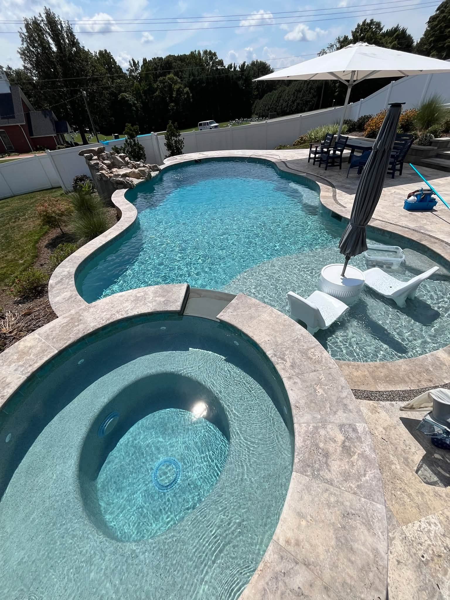 Clean residential swimming pool with attached spa and clear water