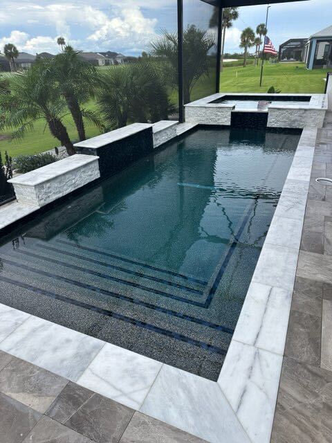 Finished Florida pool and raised spa composition with stone coping