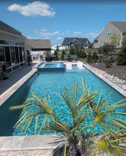 Finished swimming pool with integrated raised spa and sun shelf