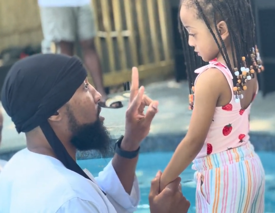 Brother Deshone kneeling and speaking with a young girl