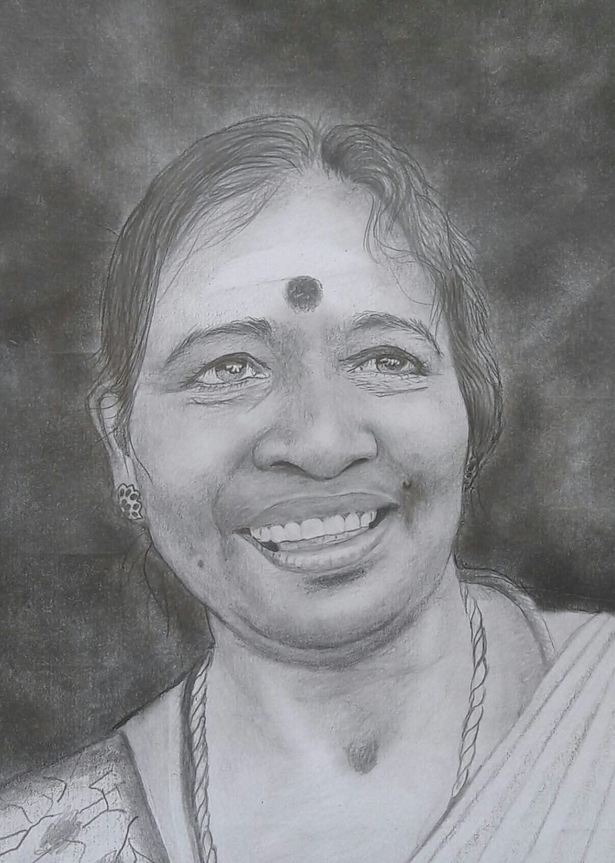 Smiling woman wearing a bindi, earrings, necklace and traditional attire