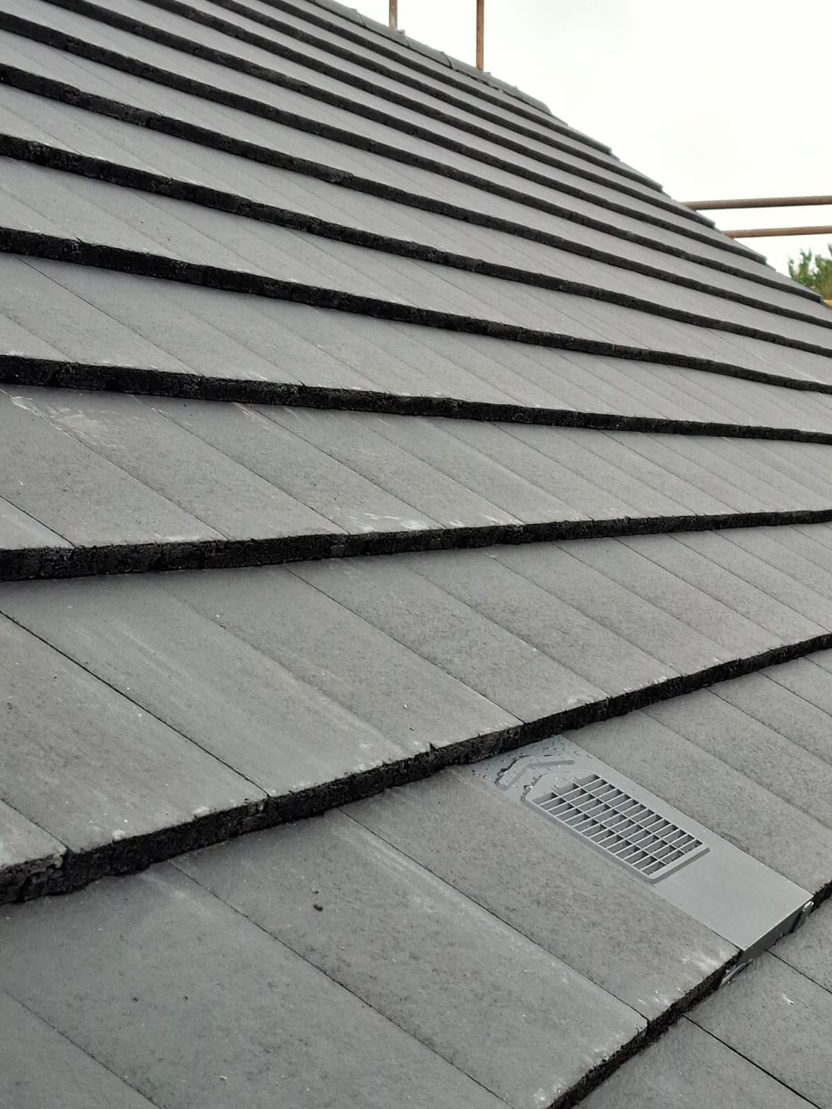 Modern low-profile concrete interlocking tile roof with inline tile vents by Smart Roofing Glasgow