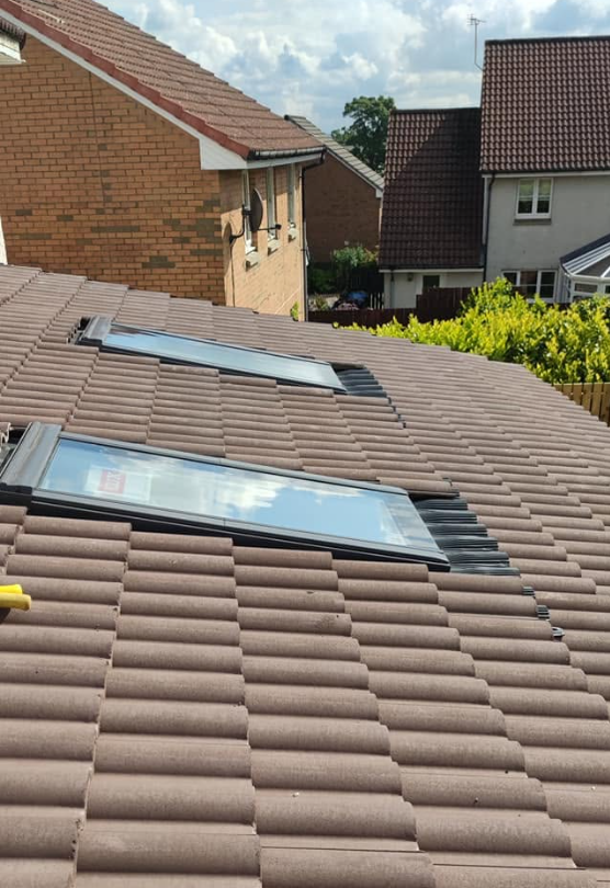 Twin Velux roof windows fitted into profiled concrete roof tiles by Smart Roofing Glasgow