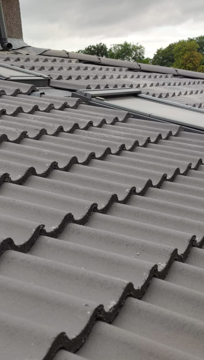 Side profile of interlocking concrete tiles and dual Velux roof windows by Smart Roofing Glasgow