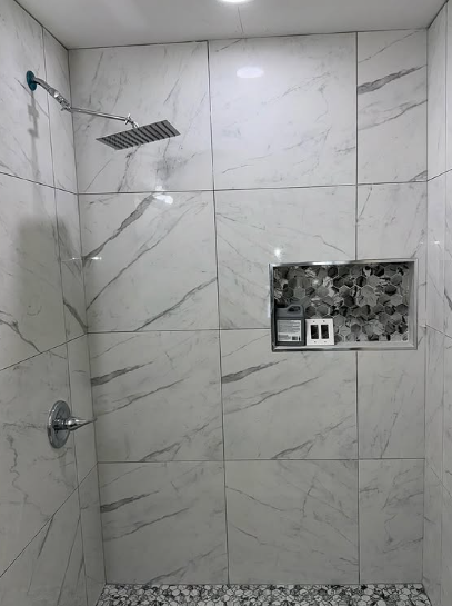 White marble shower tile with built-in hexagonal mosaic niche and rainfall fixture