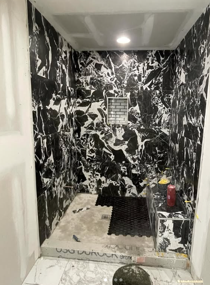 Bathroom shower under construction with Durock waterproofing, custom bench and tile prep