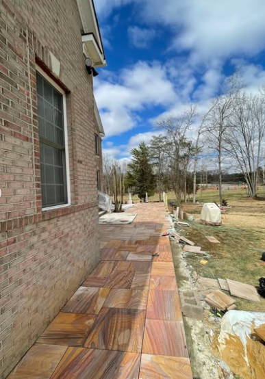 Outdoor stone tile pathway alongside residential home
