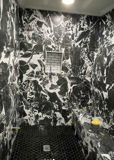 Bold black and white marble shower tile with custom bench