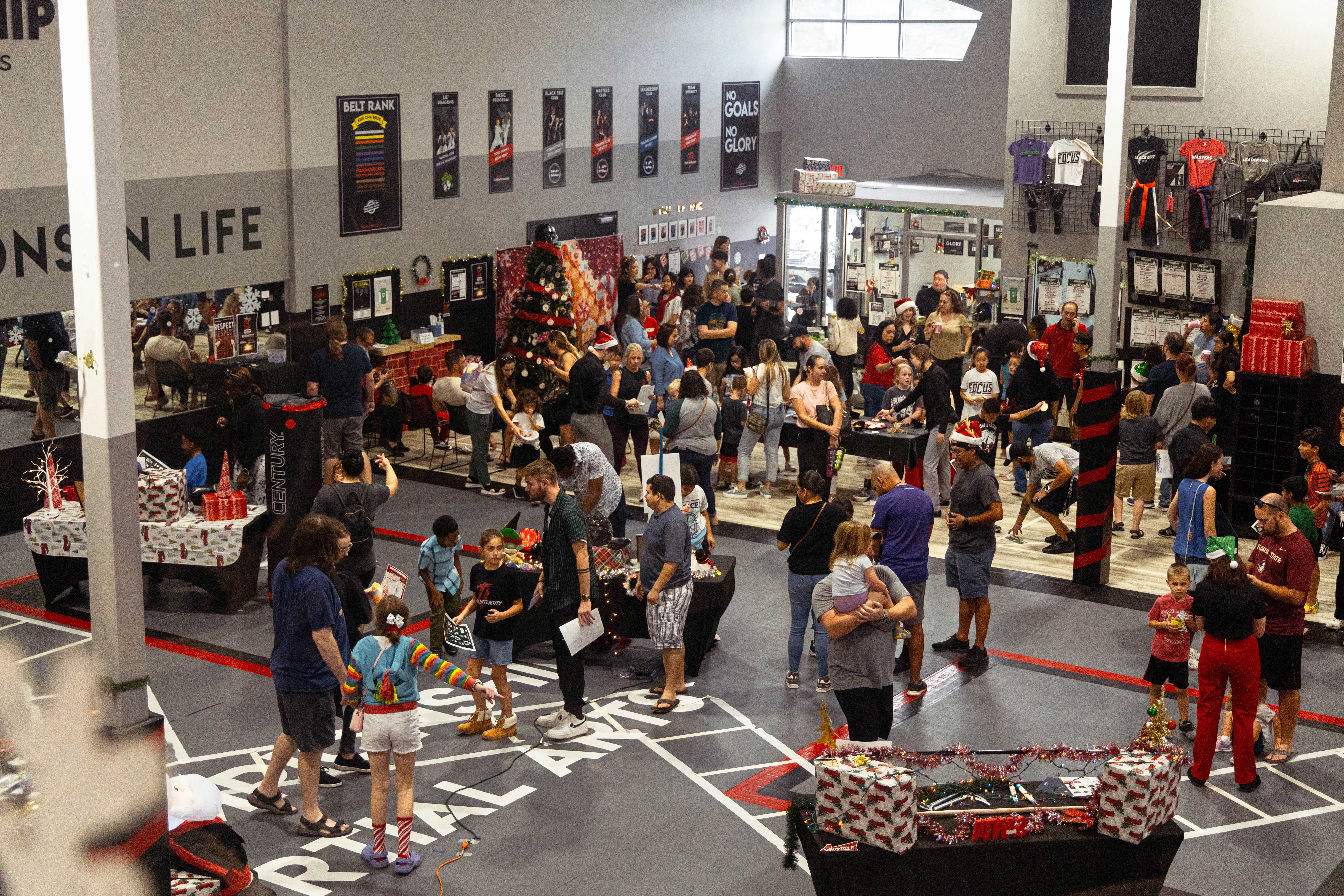 Martial arts school filled with families, students, and holiday decorations during an annual holiday event