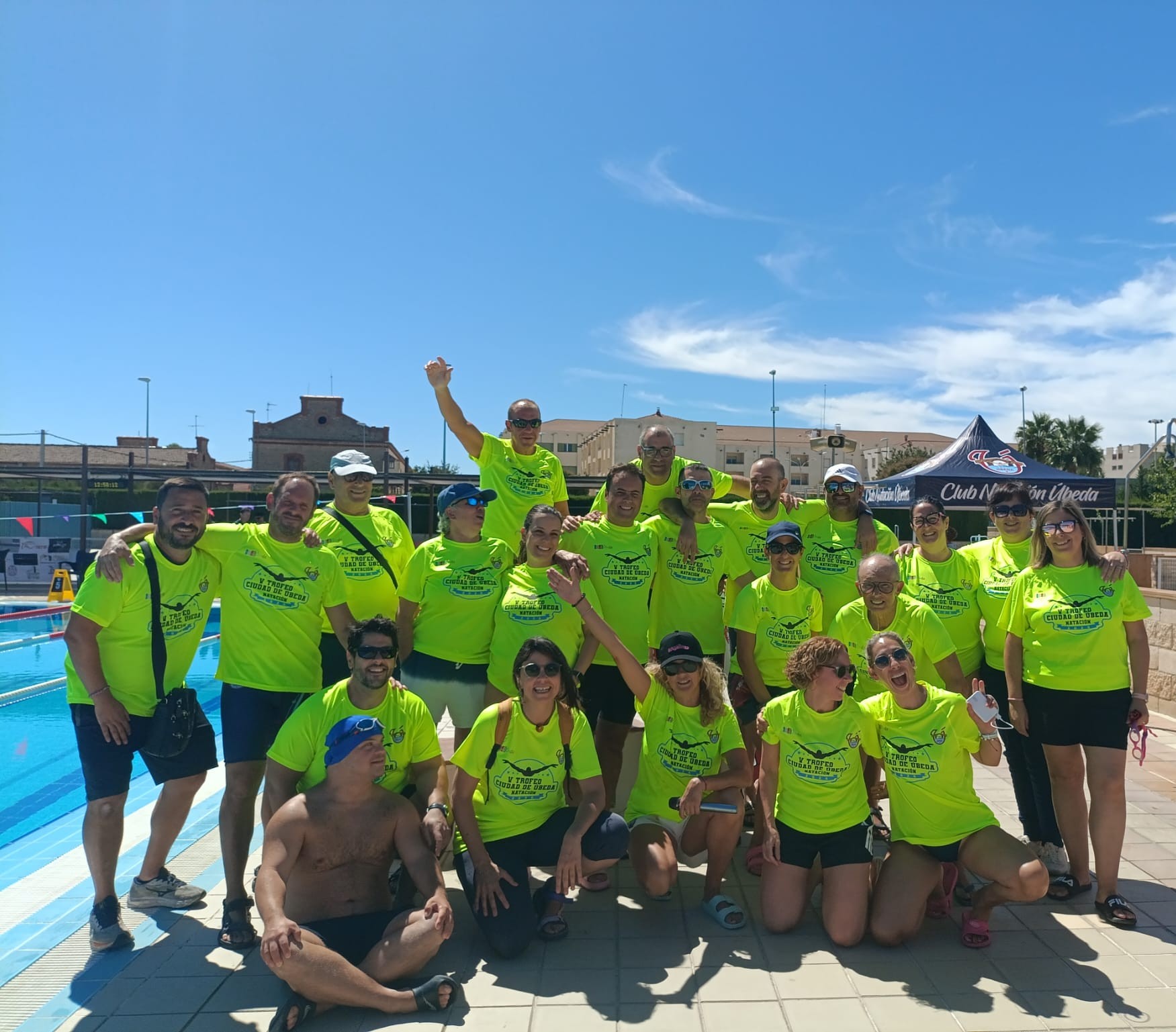 Grupo de voluntarios del club con camisetas del Trofeo Ciudad de Úbeda junto a la piscina