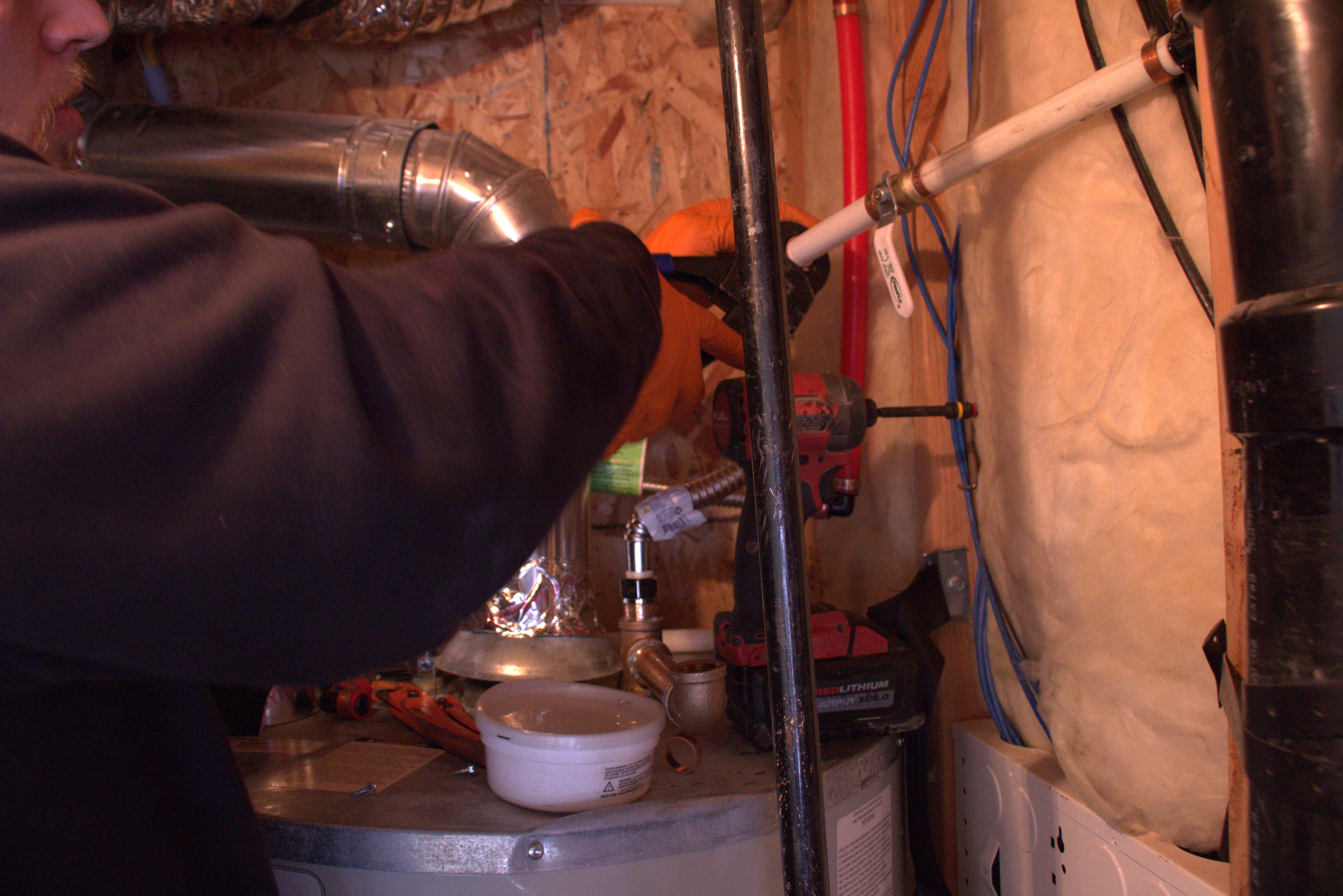 Licensed Green Line plumber repairing copper water piping and fittings on a residential water heater in Utah
