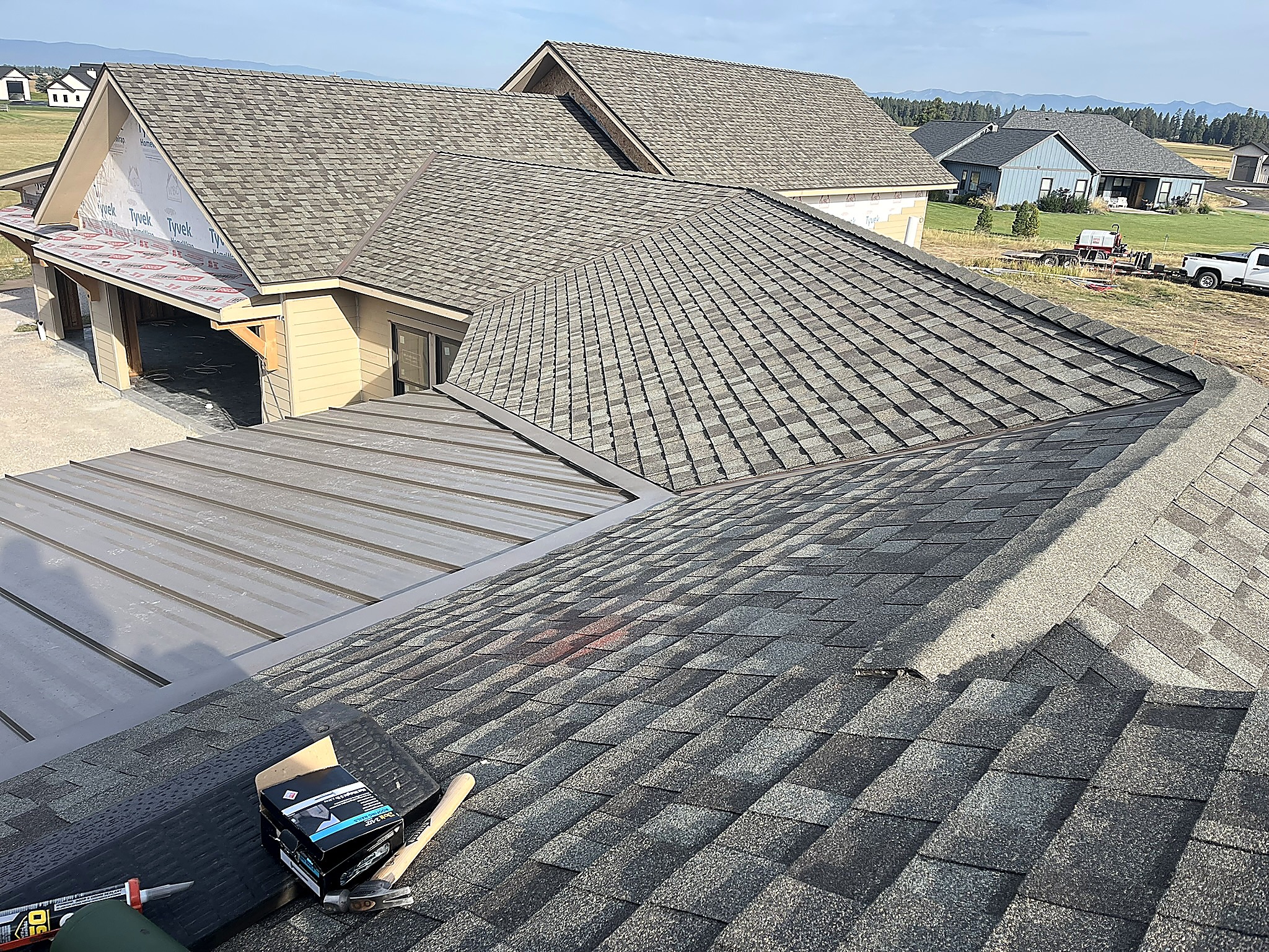 Asphalt shingle and standing seam metal roofing on the same home, Flathead Valley, Montana