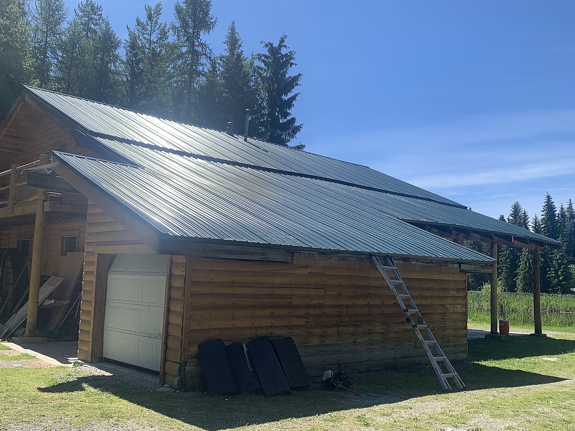 Green metal roof on a log outbuilding in the Flathead Valley, Montana