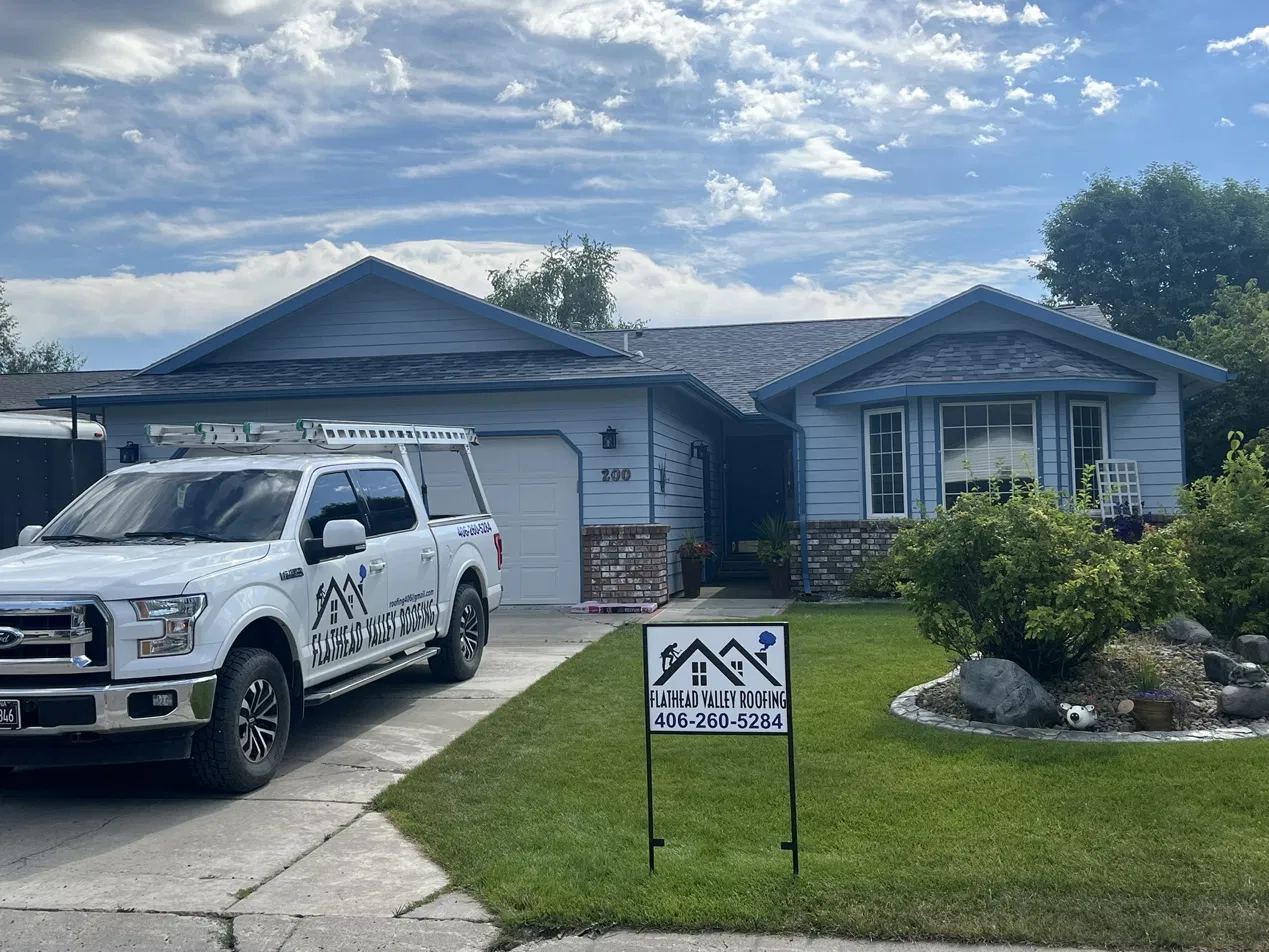 Flathead Valley Roofing truck and yard sign at a completed roofing job in Kalispell, Montana