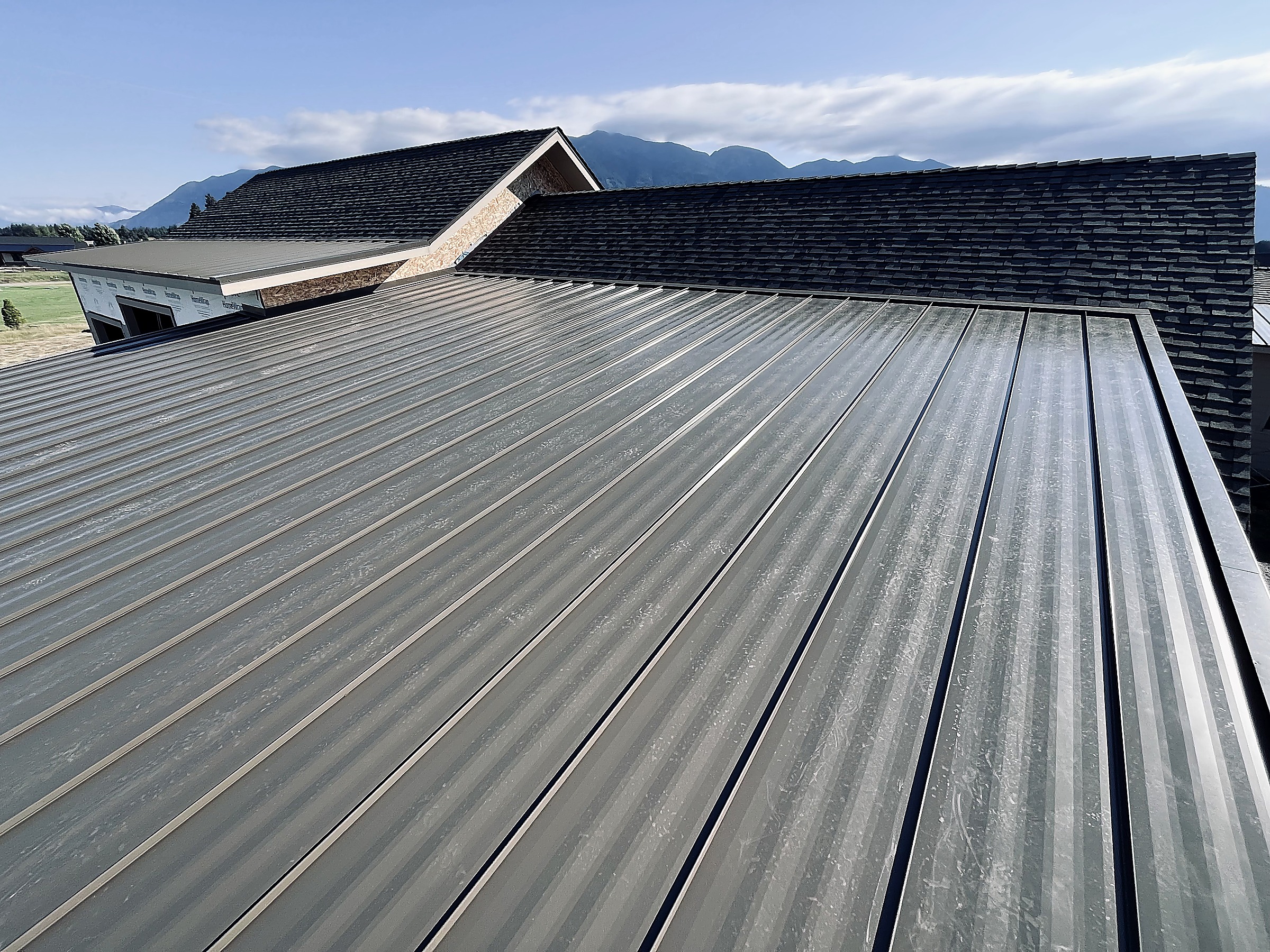 Standing seam metal roof with the Flathead Valley mountains behind, Montana