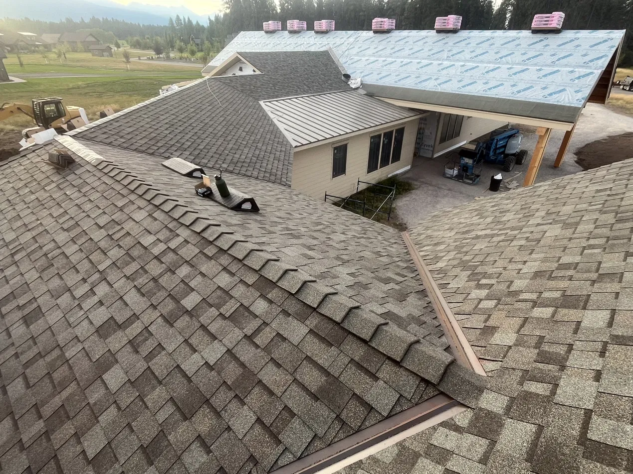 Roof replacement in progress with underlayment and shingle bundles, Flathead Valley, Montana