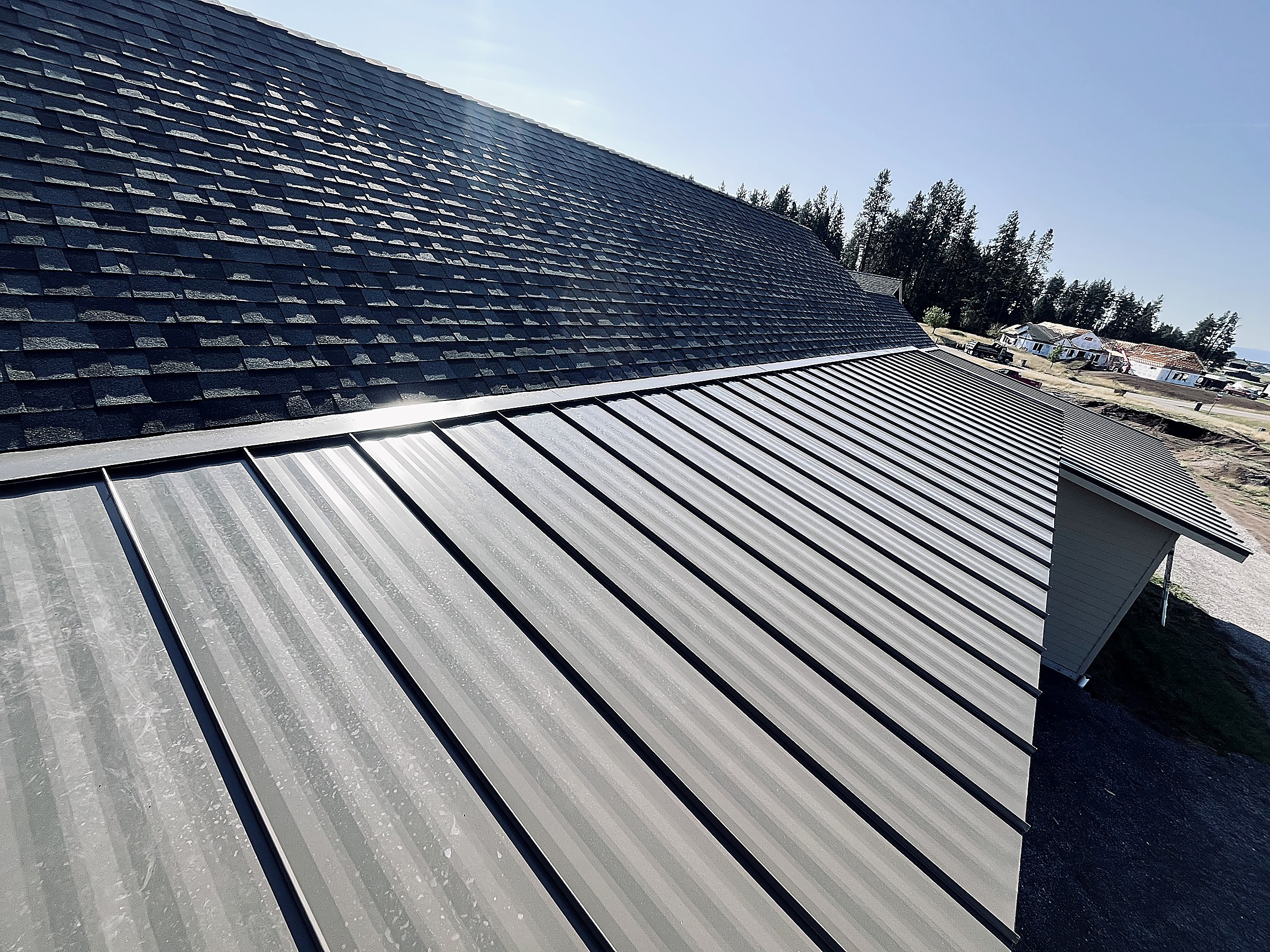 Standing seam metal roofing beside an asphalt shingle roof, Flathead Valley, Montana