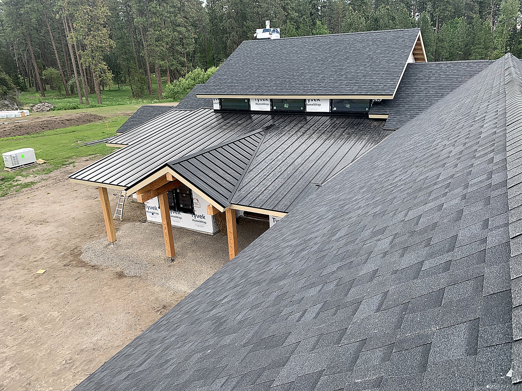 Asphalt shingle and black standing seam metal roofing on a home in the Flathead Valley, Montana