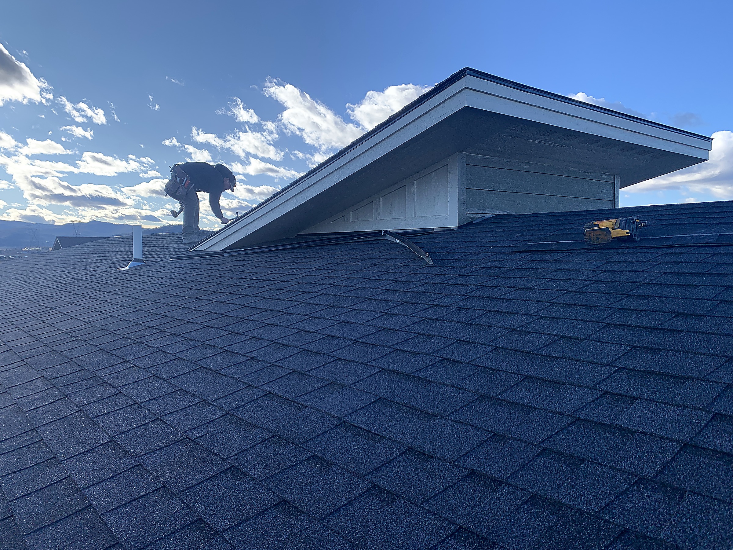 Flathead Valley Roofing crew member working at a dormer on a shingle roof, Montana