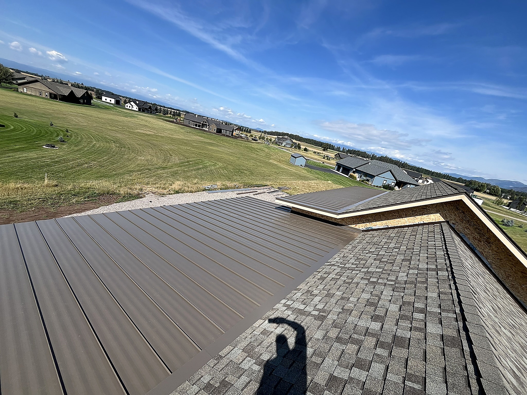 Standing seam metal roofing meeting asphalt shingles, Flathead Valley, Montana