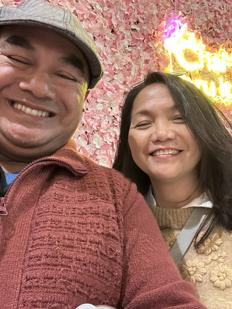 Guests smiling at Chai & Co. floral selfie wall