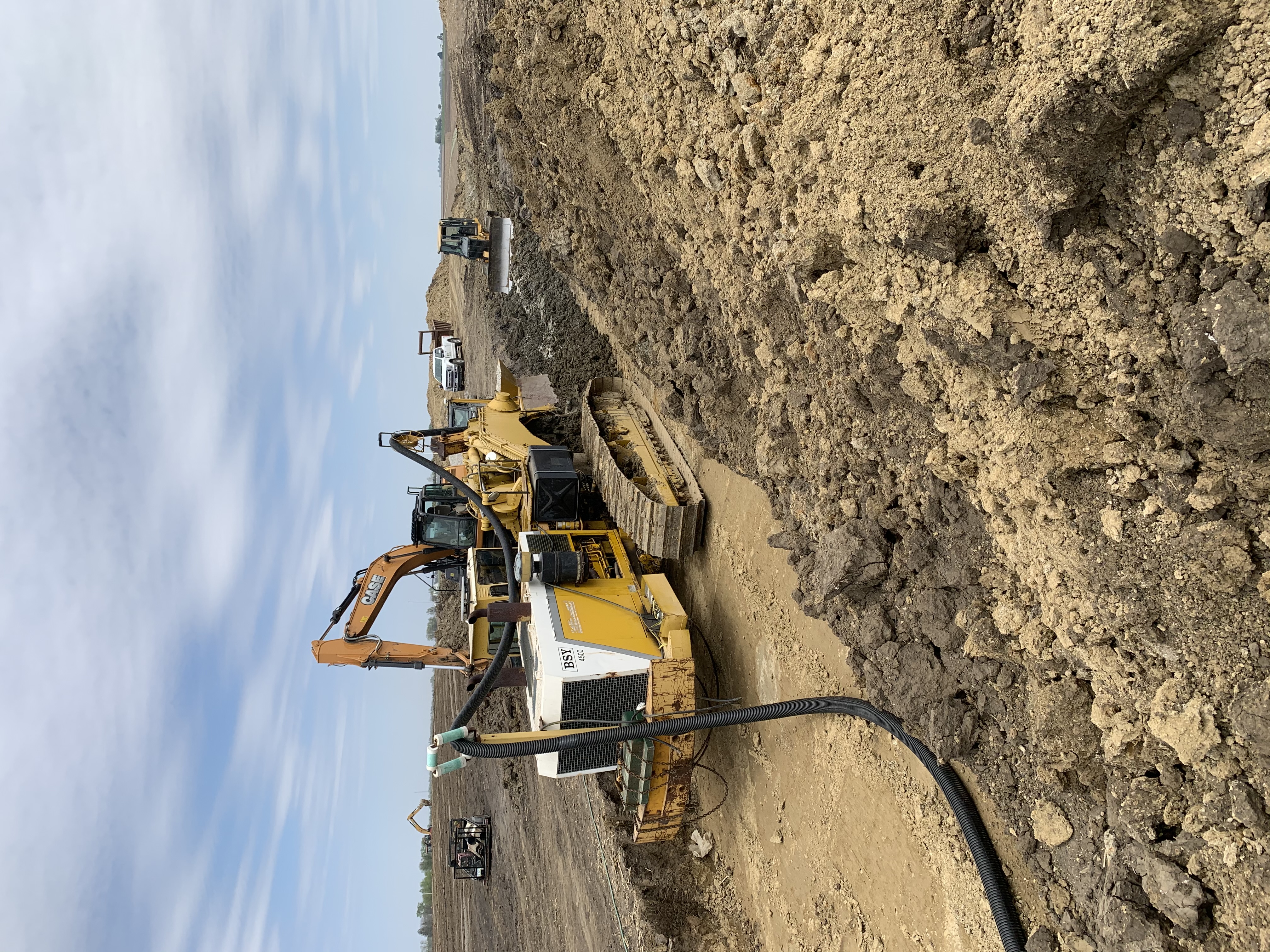 Heavy dewatering equipment and excavator managing groundwater control on site.