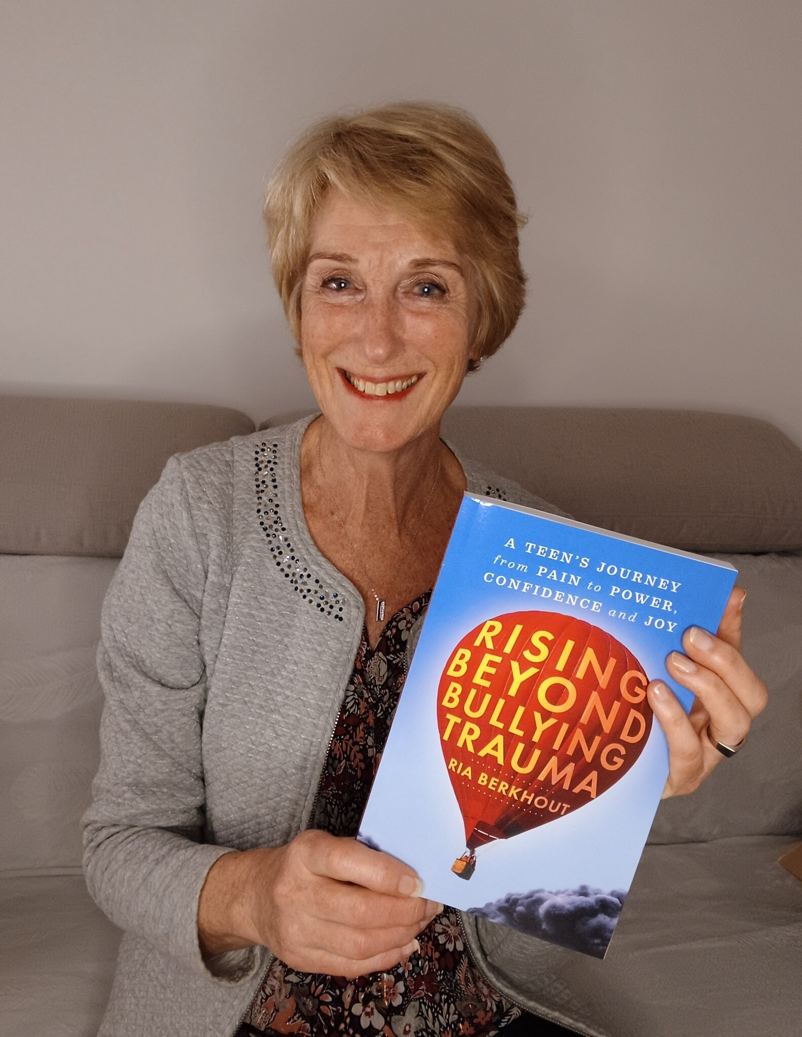 Ria Berkhout holding Rising Beyond Bullying Trauma