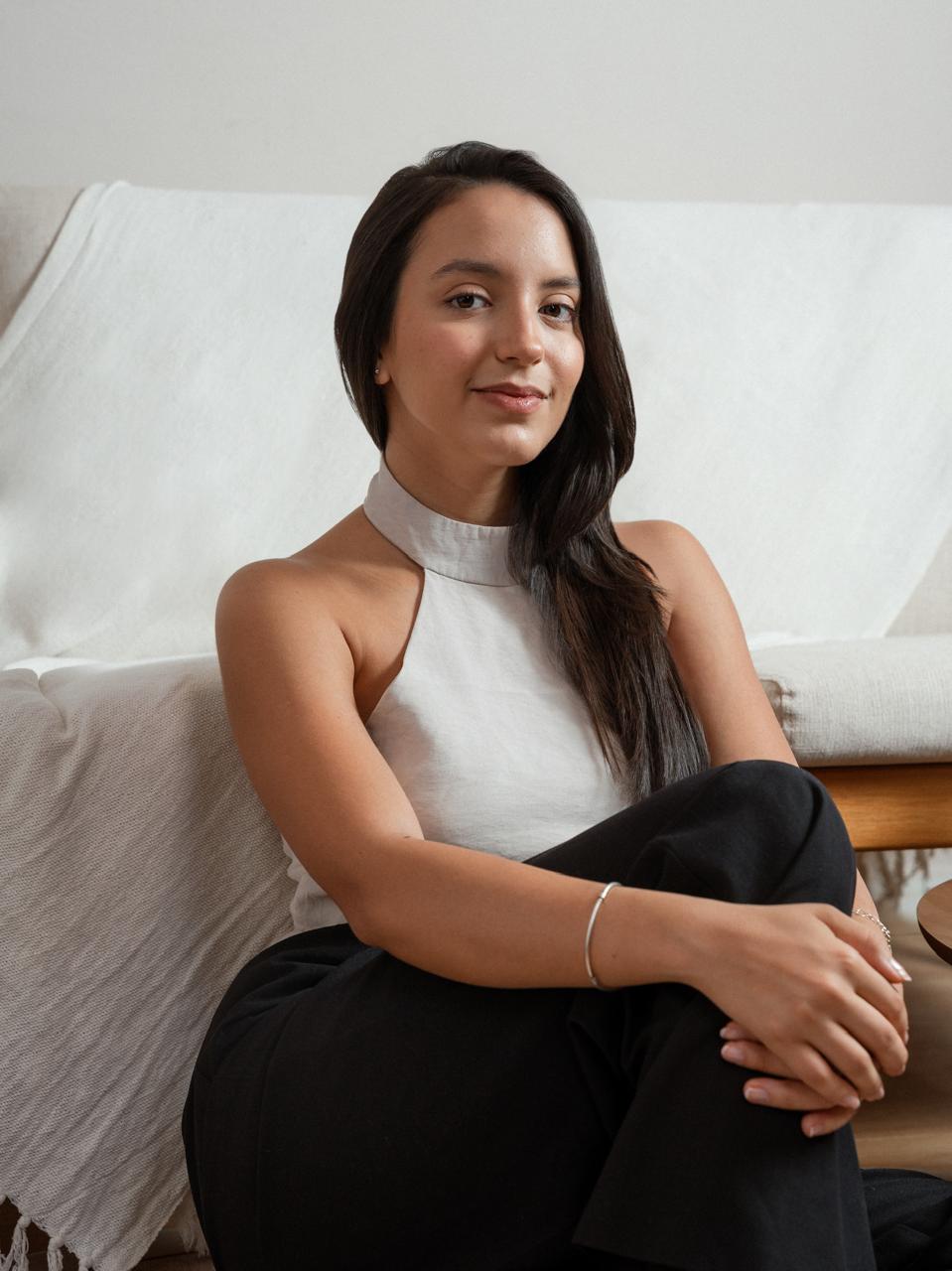 Foto de Lívia Uener, psicóloga, com postura atenta e acolhedora em ambiente suave