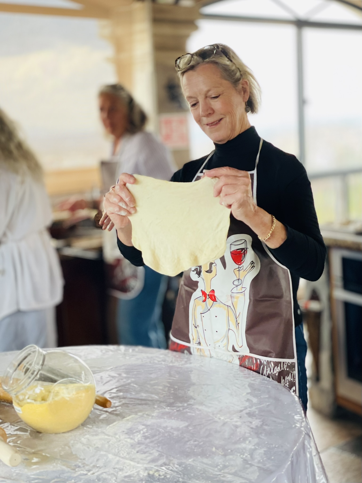 Guest stretching fresh pizza dough during a rooftop culinary workshop at Casa Grande