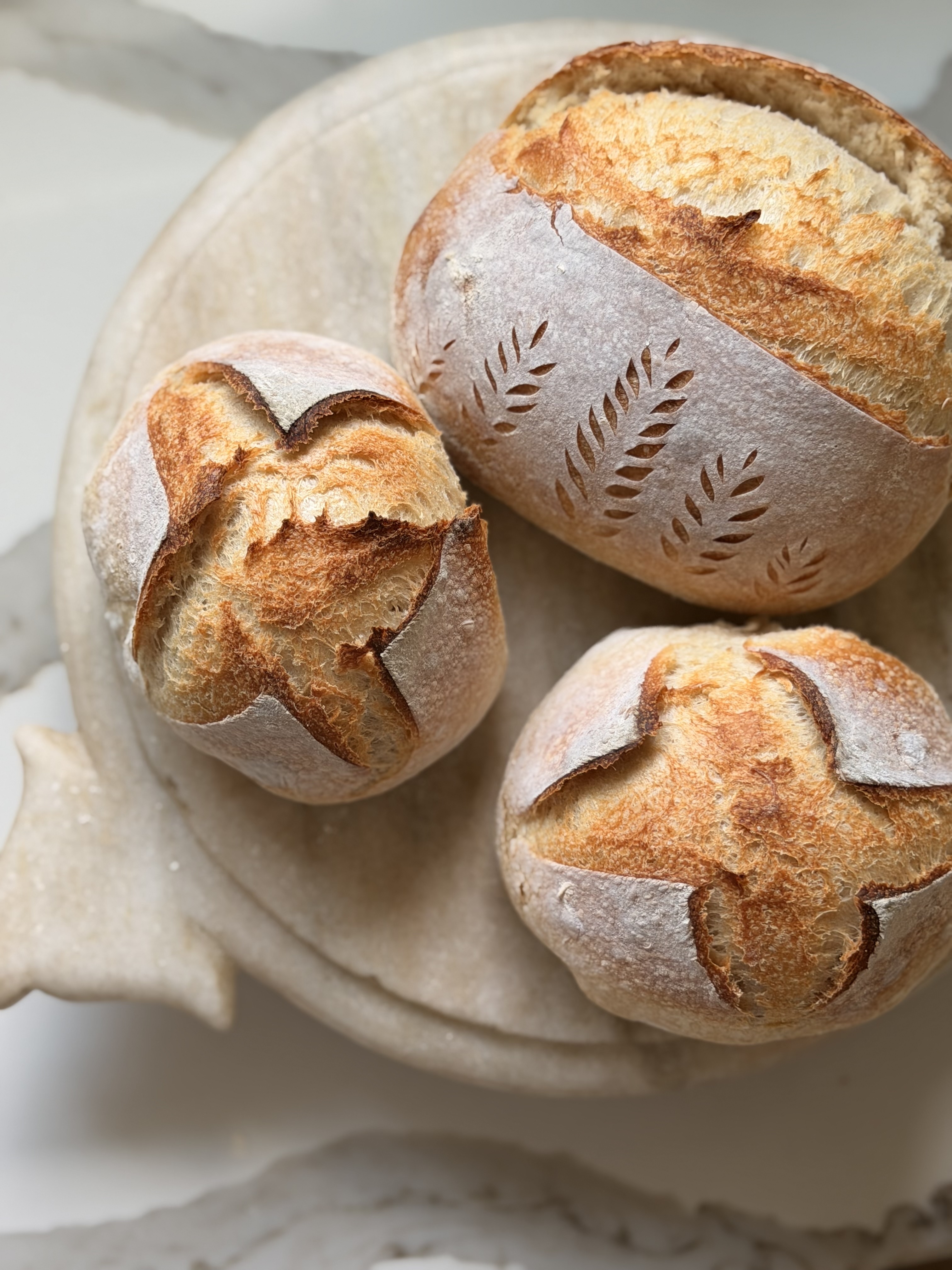 Handcrafted artisan sourdough boules with signature scored wheat detailing