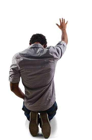 Hombre arrodillado levantando una mano en adoración
