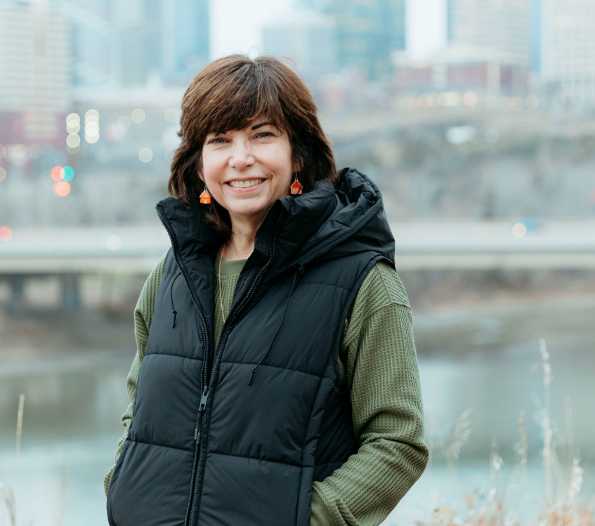 Wendy Theberge outdoors overlooking Edmonton's river valley and skyline