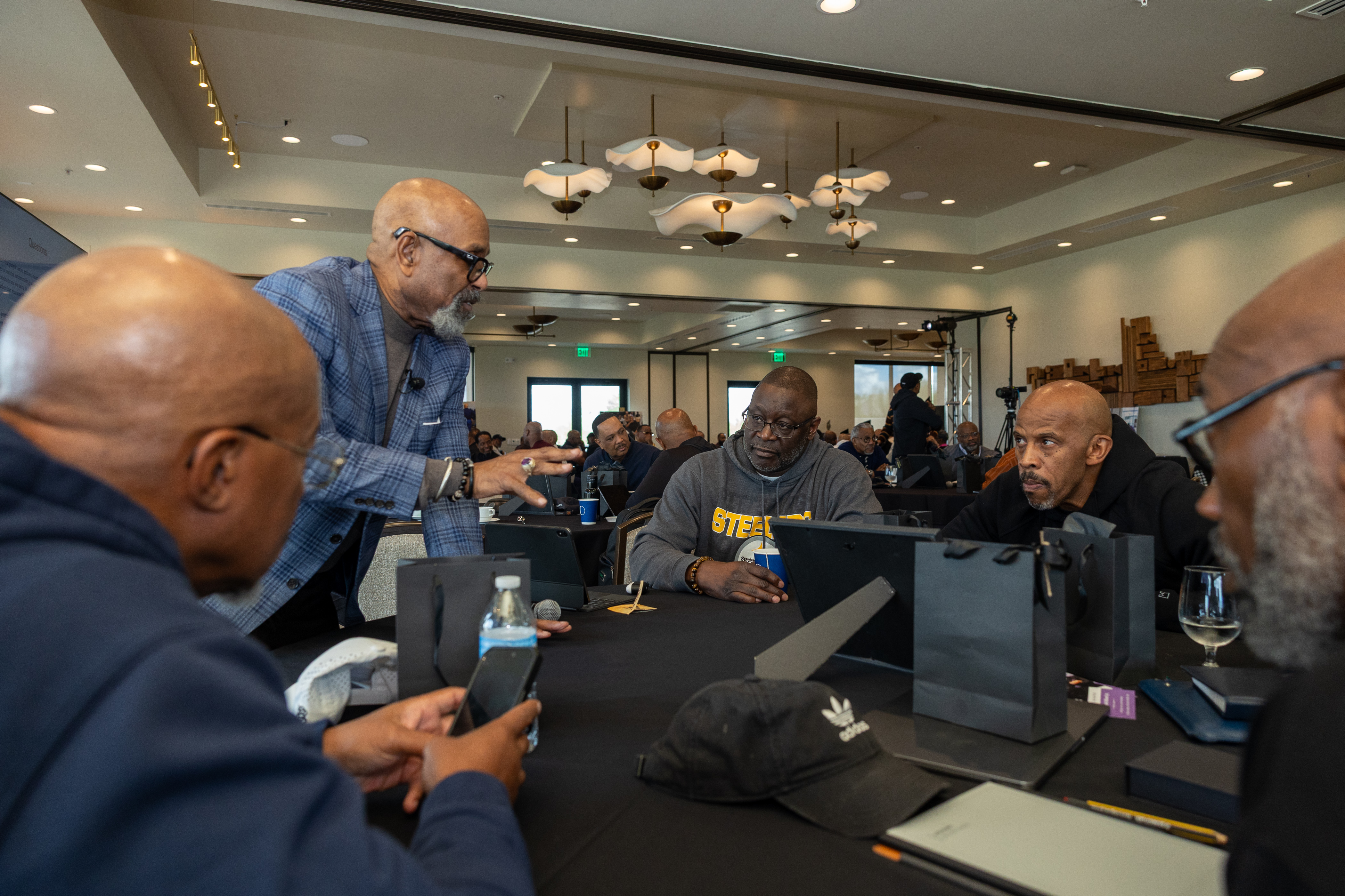 Pastors gathered around a working table with binders and notebooks, deep in planning