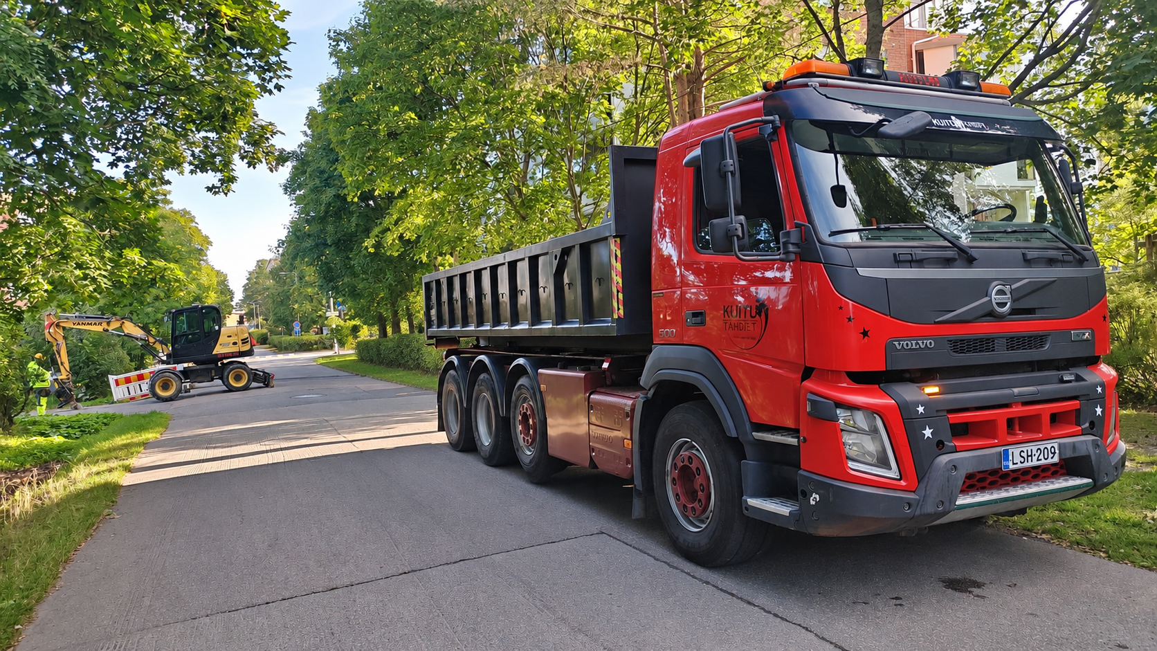Kuitutähtien kuorma-auto ja kaivinkone kuitukaapelityömaalla — avoimet työpaikat
